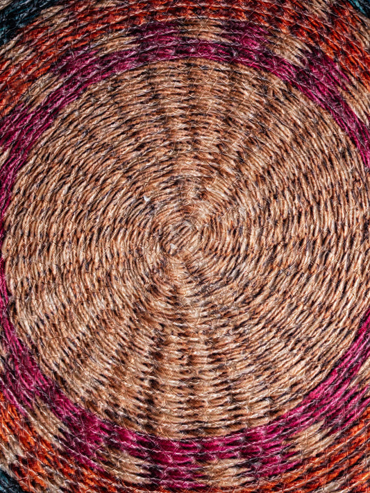 A Round, braided jute chair pad buttermilk and cranberry color